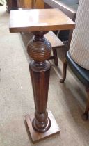 A Victorian mahogany torchère with turned and fluted pillar, set on square base