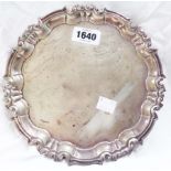 A 20.5cm diameter silver salver by Willam Hutton with cast scroll rim, set on triple scroll feet -