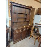 A 1.35m antique oak two part dresser with three shelf open plate rack and flanking small cupboard