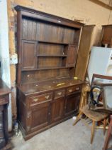 A 1.35m antique oak two part dresser with three shelf open plate rack and flanking small cupboard