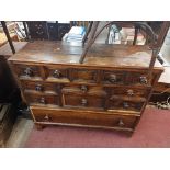 A 1.11m antique inlaid oak chest with central blind drawer and an array of eleven further drawers,
