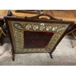 A large wooden fire screen inset with glazed decorative silk and velvet embroidery