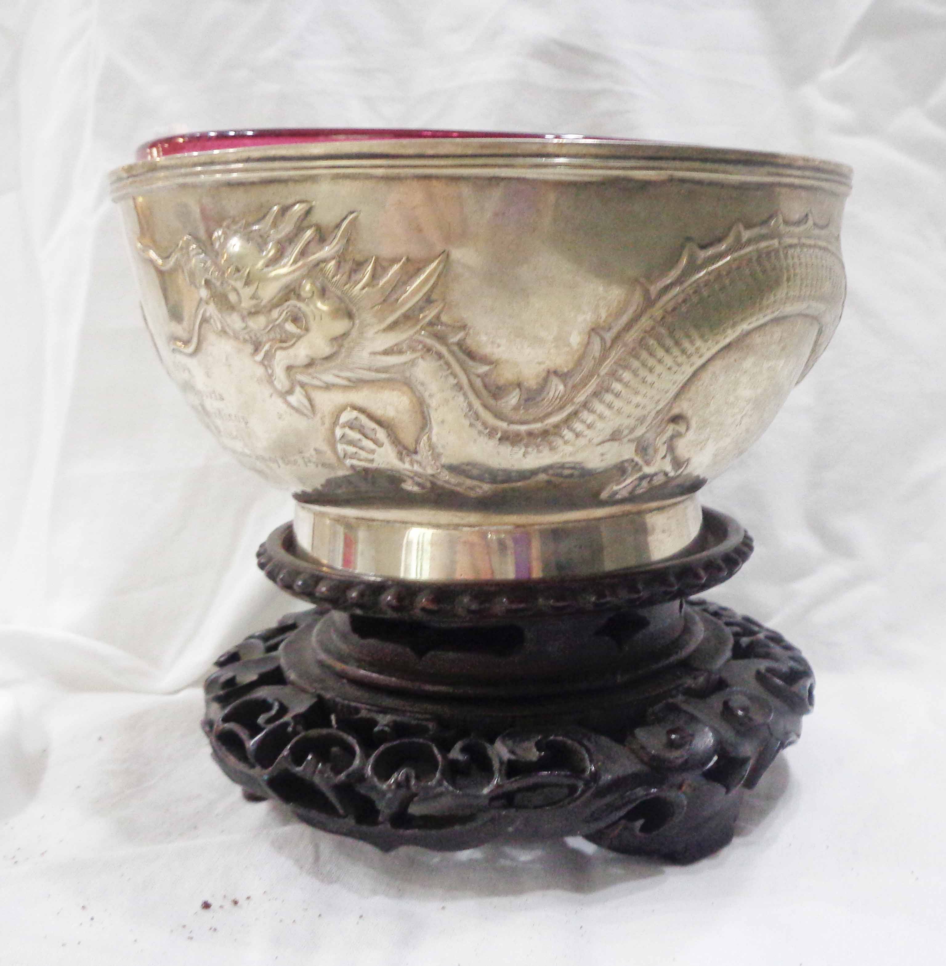 A 13.5cm diameter early 20th Century Chinese Wo Shing white metal footed bowl with embossed writhing