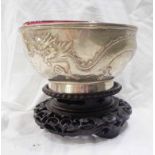 A 13.5cm diameter early 20th Century Chinese Wo Shing white metal footed bowl with embossed writhing