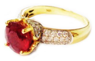 A marked 10k ring, set with central circular heat treated ruby with tiny diamonds to shoulders -