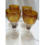 Four early 20th Century amber cased over clear glass goblets, with facet cut decoration and etched