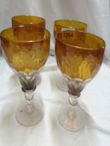 Four early 20th Century amber cased over clear glass goblets, with facet cut decoration and etched