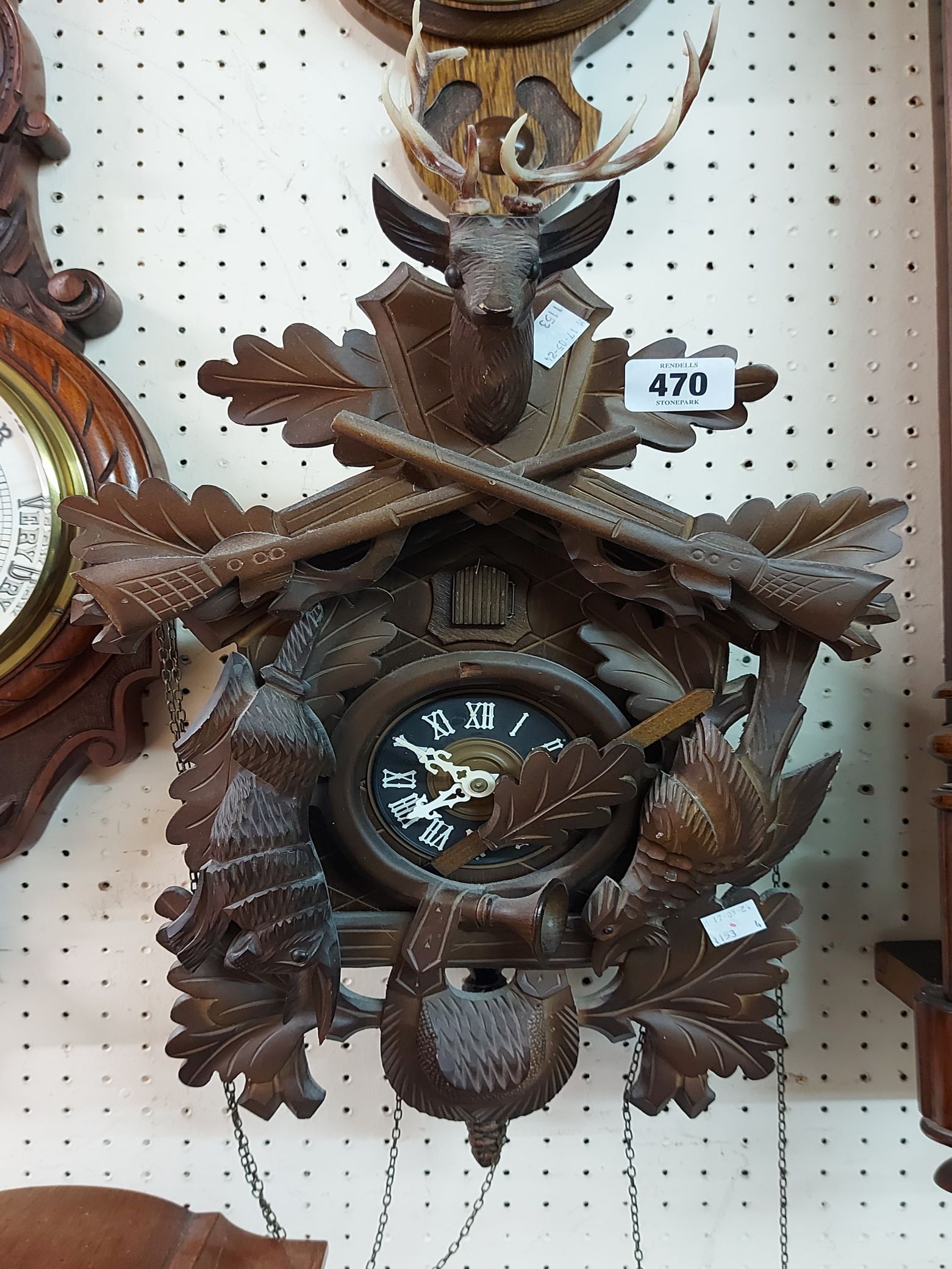 A vintage stained wood and resin cased cuckoo clock with deer head pattern pediment, further applied