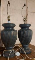 A pair of large black urn style ceramic lamp bases with coppered highlights