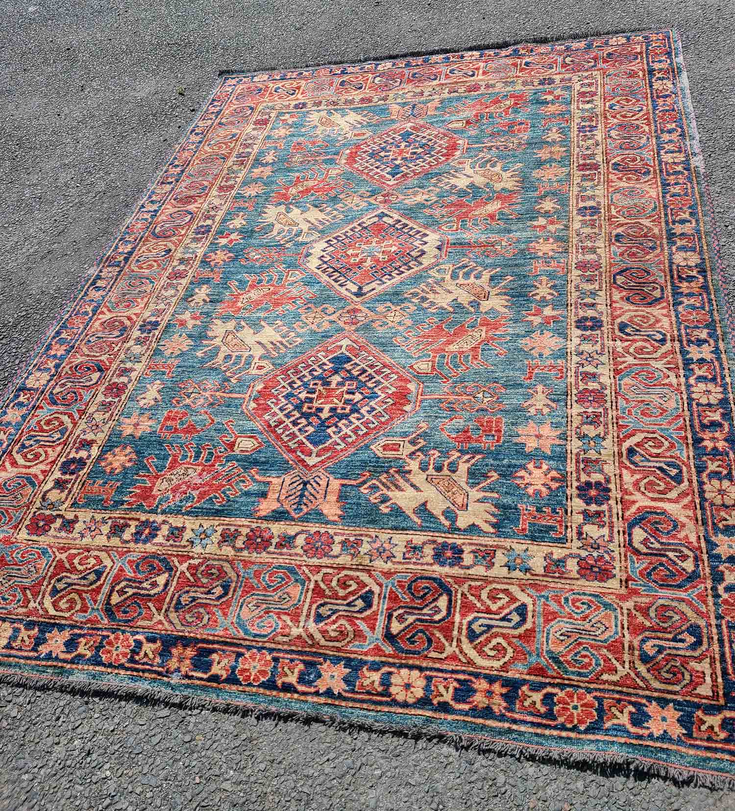 An old Persian handmade wool rug with repeat motifs on a blue and red ground - 1.5m X 1.85m