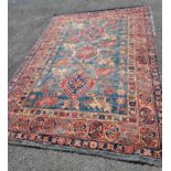 An old Persian handmade wool rug with repeat motifs on a blue and red ground - 1.5m X 1.85m