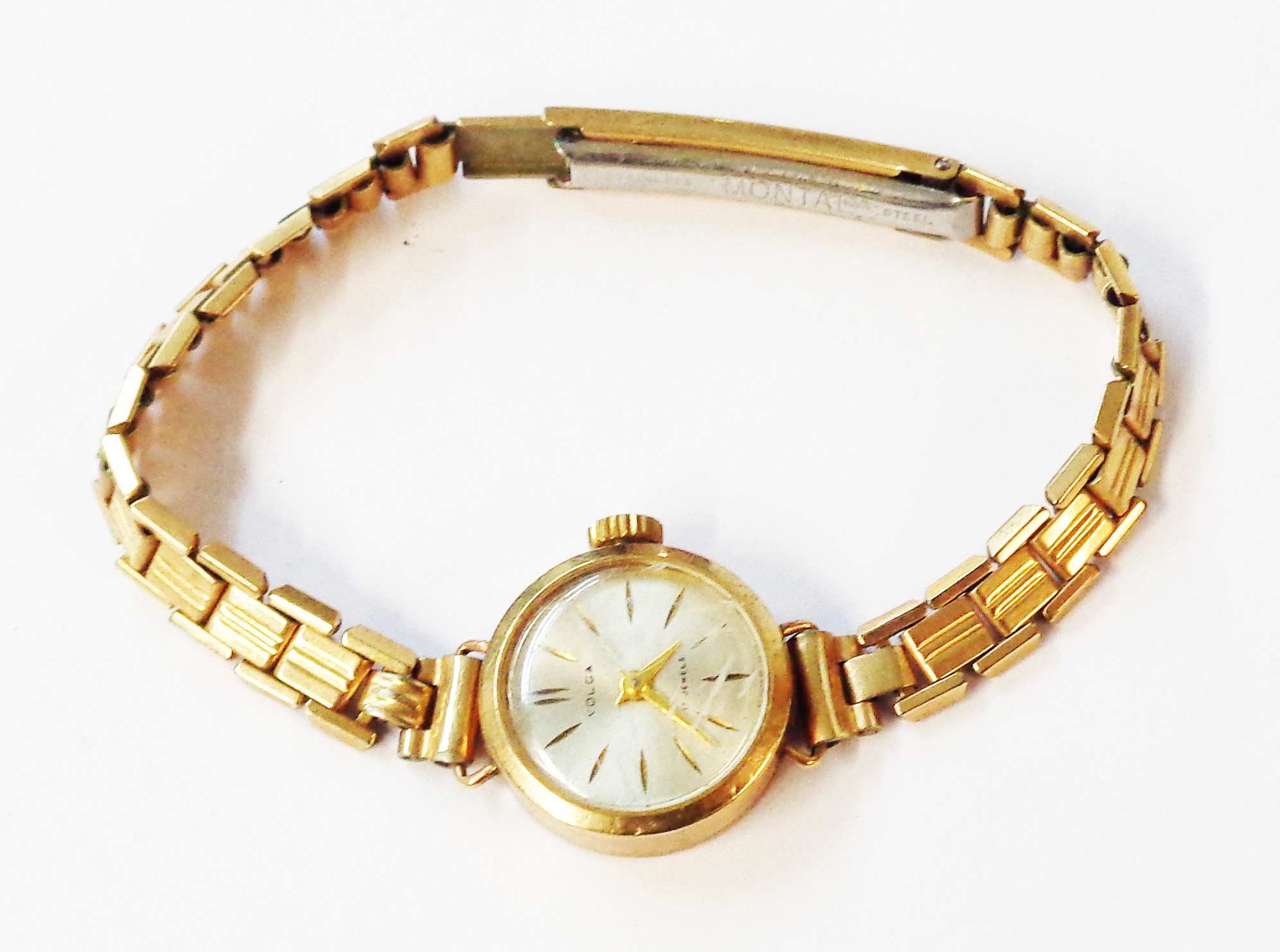 A 1989 Volga 375 (9ct.) gold cased lady's wristwatch, on gold plated bracelet - in associated