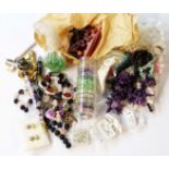 A wash bag containing a quantity of jewellery beads, part necklaces and other costume jewellery,