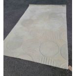 A modern wool rug with circular pattern on white ground