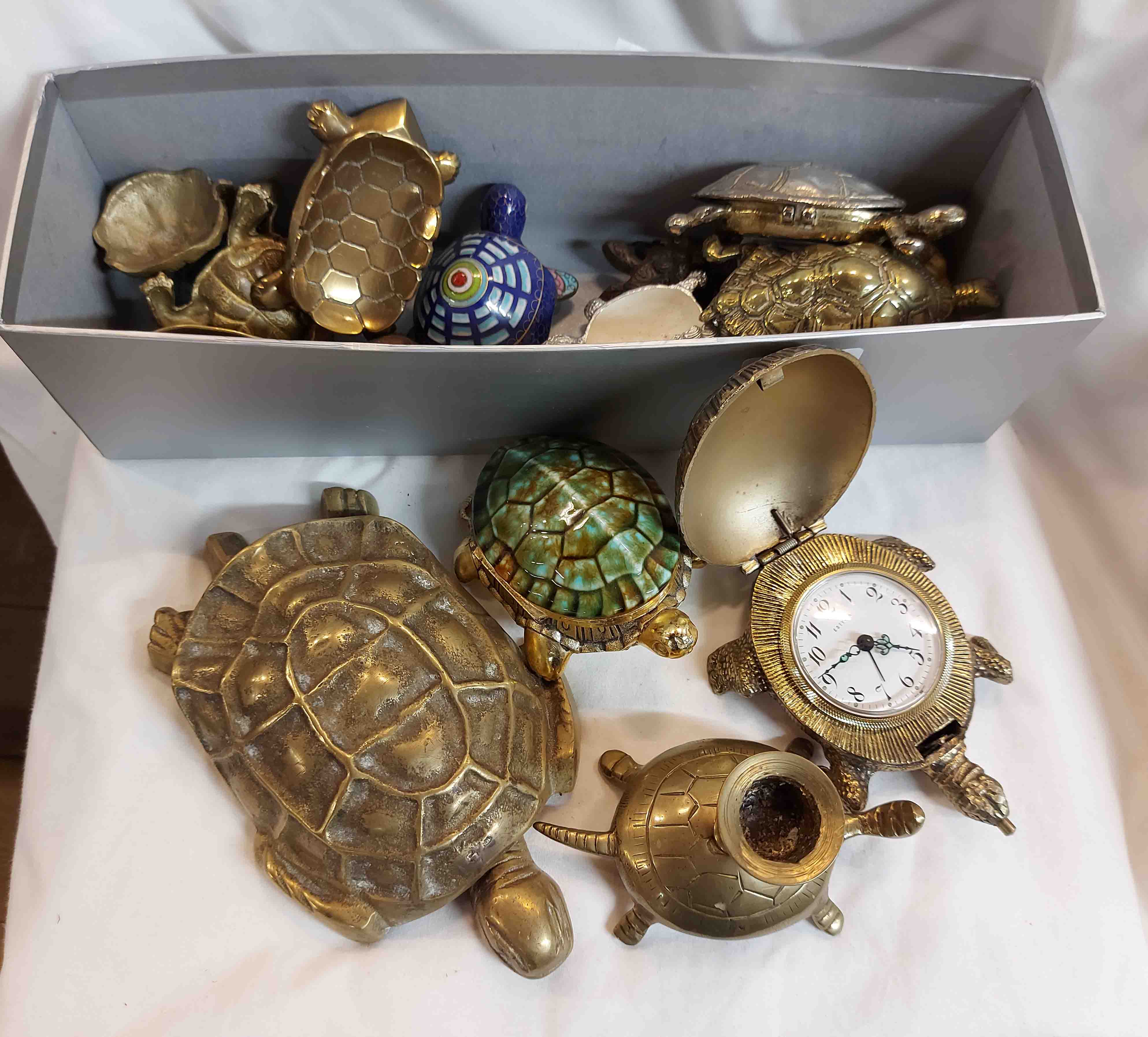 A box containing a large quantity of brass tortoise figurines of various design and function