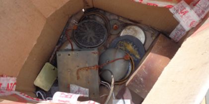 A box containing a quantity of assorted clock parts including longcase dial, part movements,