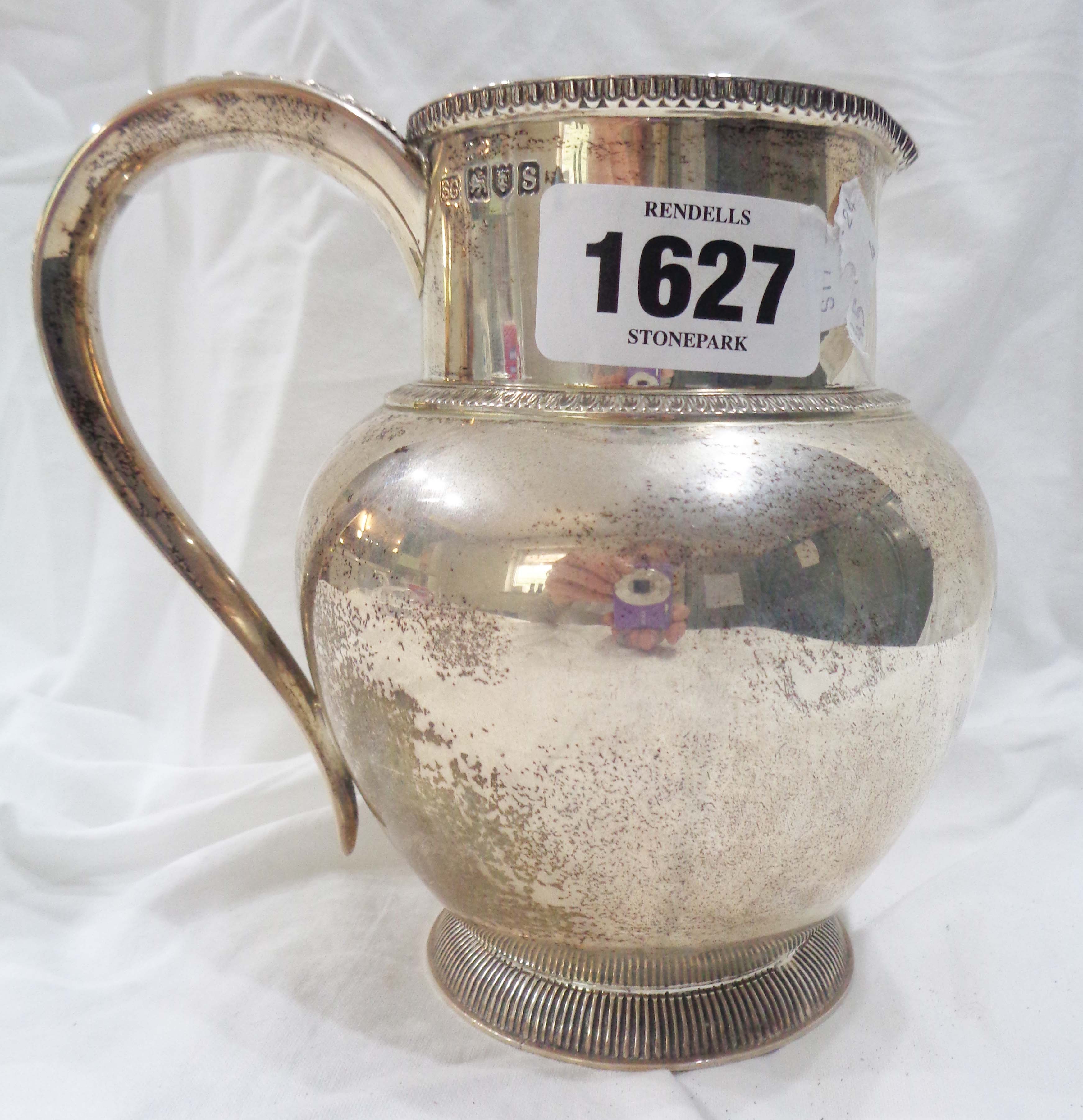 An antique silver milk jug with acanthus decorated handle by Garrard & Co. Ltd., bearing