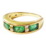 A 750 (18ct.) gold ring with four channel set emeralds interspersed with tiny diamonds - size O 1/2