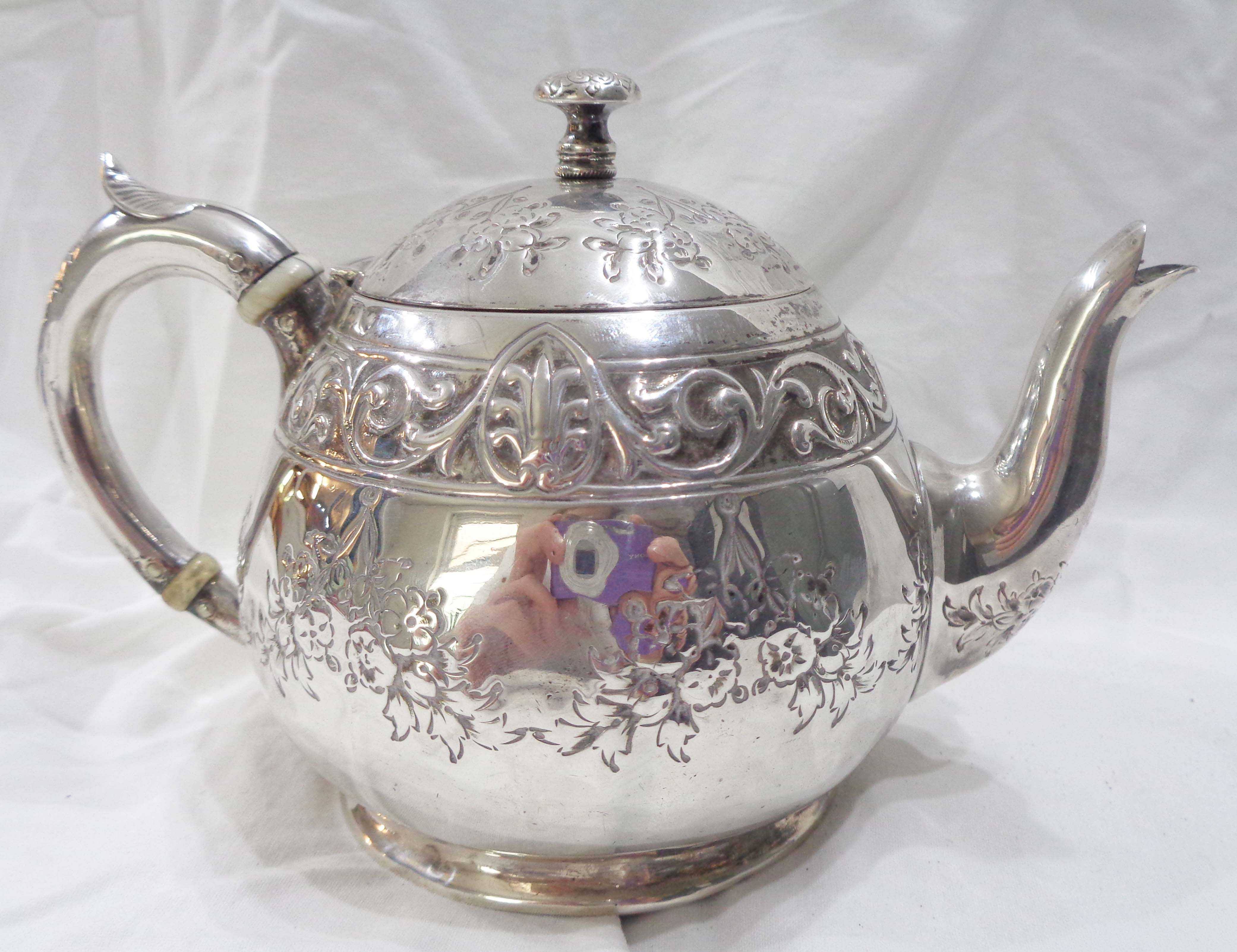 A small Victorian silver globular teapot with embossed floral swag and scroll decoration by Henry