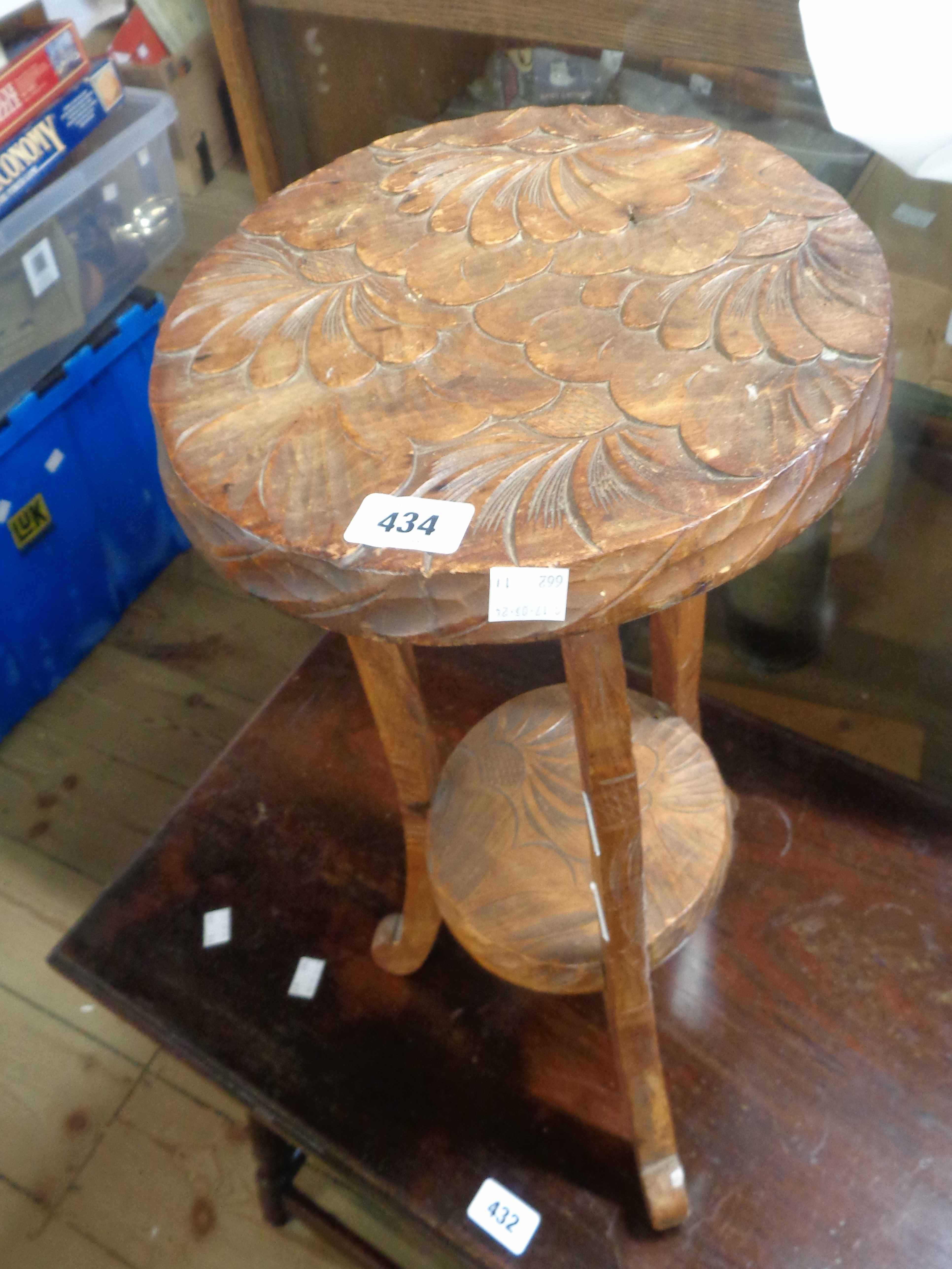 A small Eastern carved wood table with floral petal decoration, set on cabriole supports with