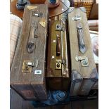 Three old canvas and leather bound suitcases