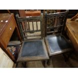 A pair of antique stained and carved oak spindle back standard chairs with studded seat panels