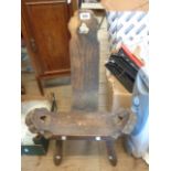 A vintage rustic stained wood spinning chair with bow seat panel