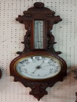 A late Victorian walnut cased banjo barometer/thermometer with carved and pierced decoration and