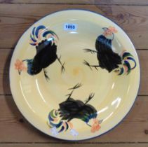 A large pottery dish with hand painted cockerel decoration