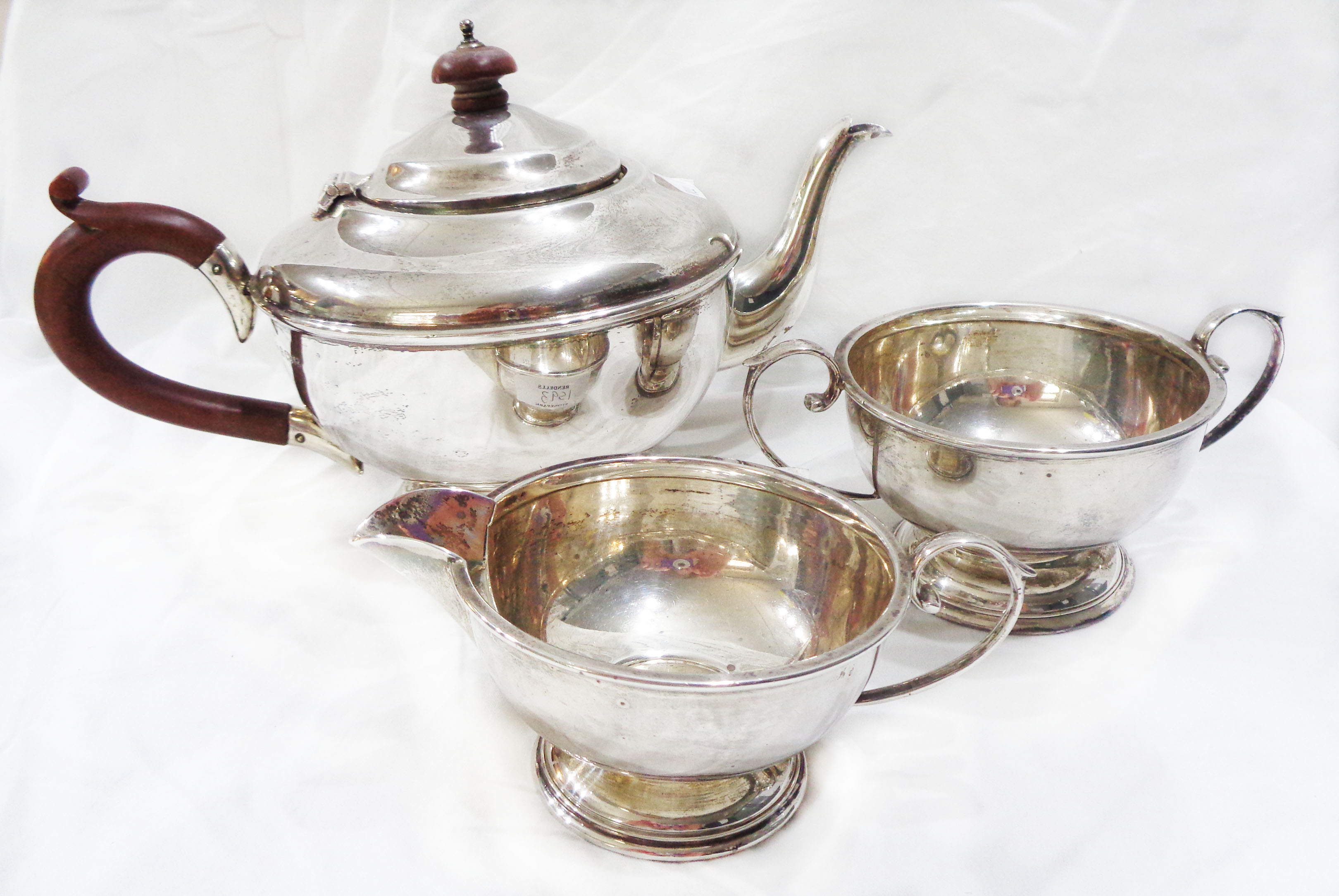 A silver three piece tea set of footed form with composite knop and handle to teapot - Birmingham