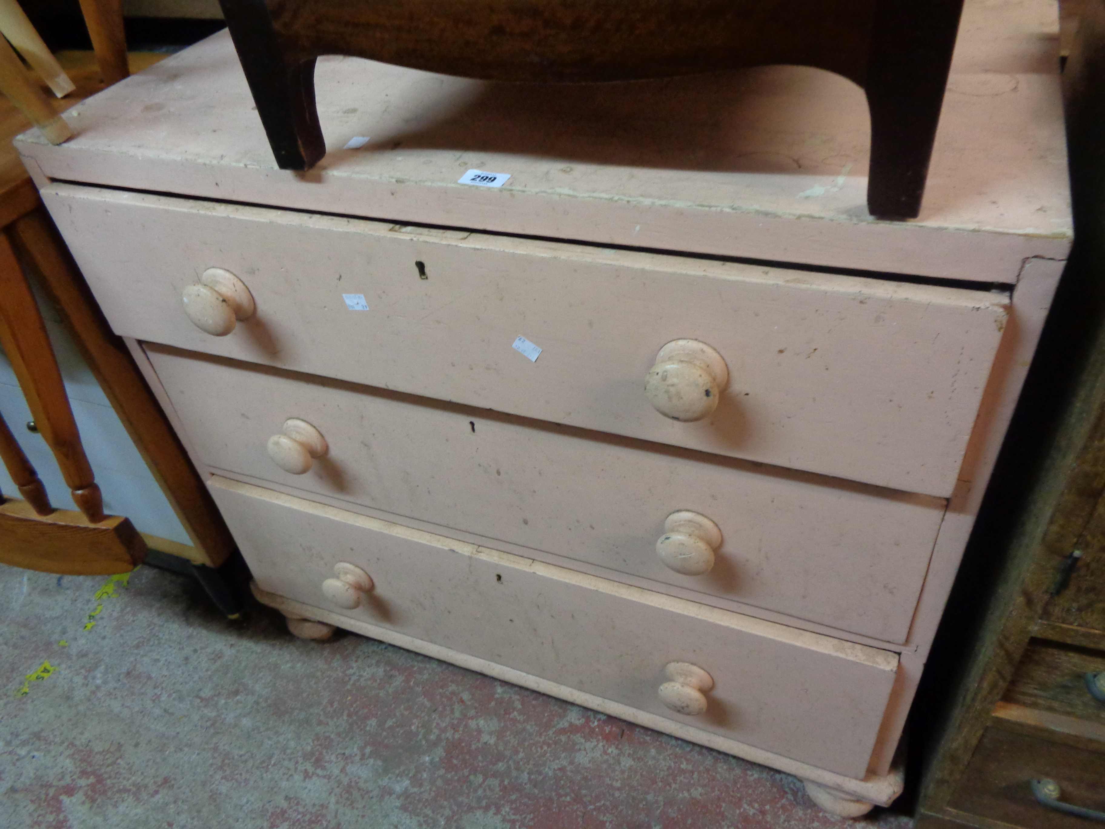 A 91cm later pink painted chest of three long graduated drawers, set on turned feet