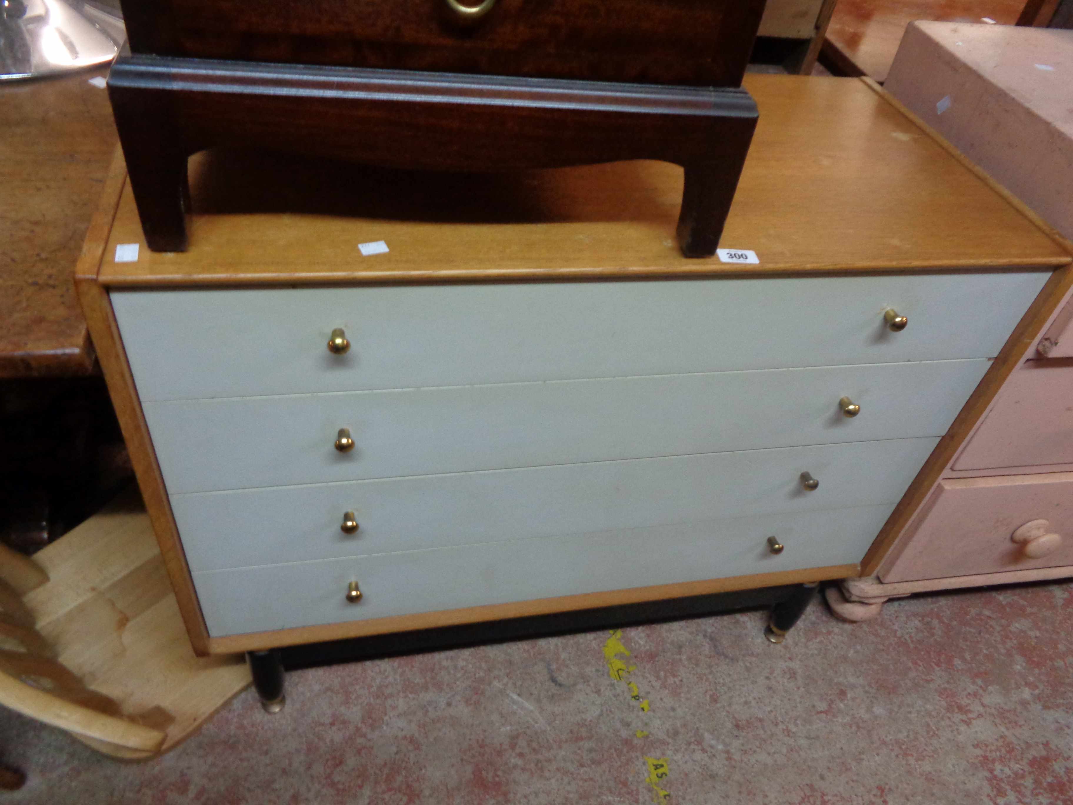 A 96cm retro G-Plan part painted chest of four long drawers, set on tapered legs with brass feet -