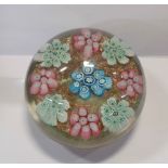 A vintage Murano glass paperweight with cluster millefiori decoration on an aventurine ground