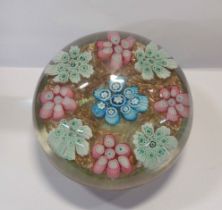 A vintage Murano glass paperweight with cluster millefiori decoration on an aventurine ground