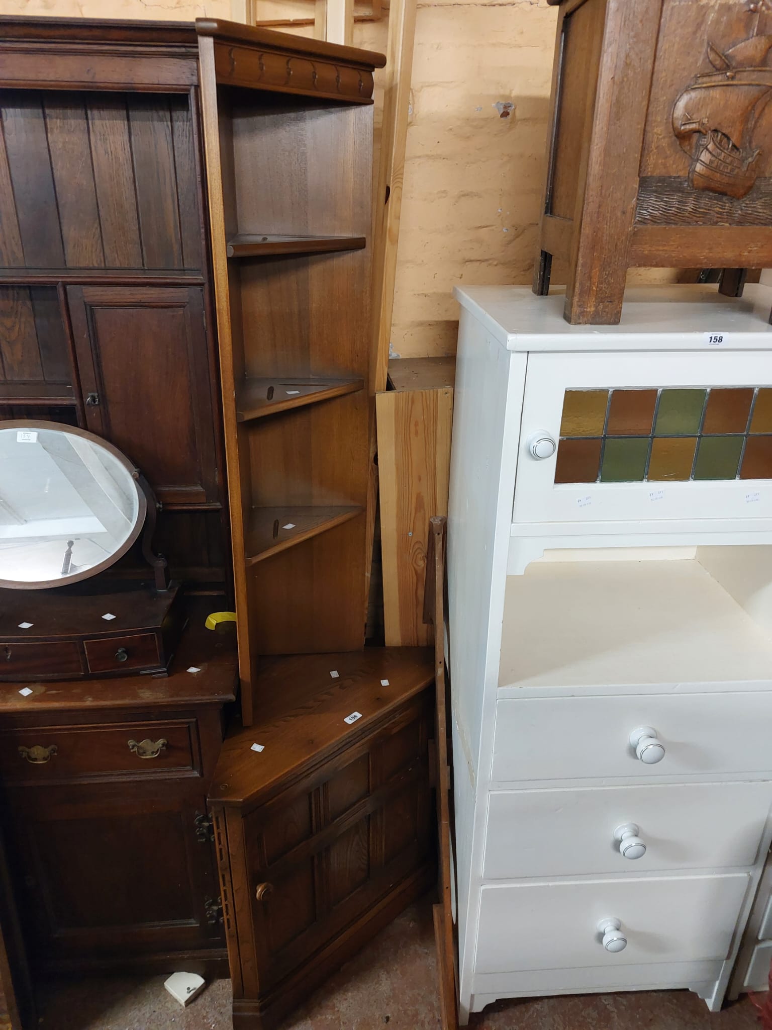 A 68cm Ercol dark elm three shelf corner unit with cupboard to base, set on plinth base - 1.98mn