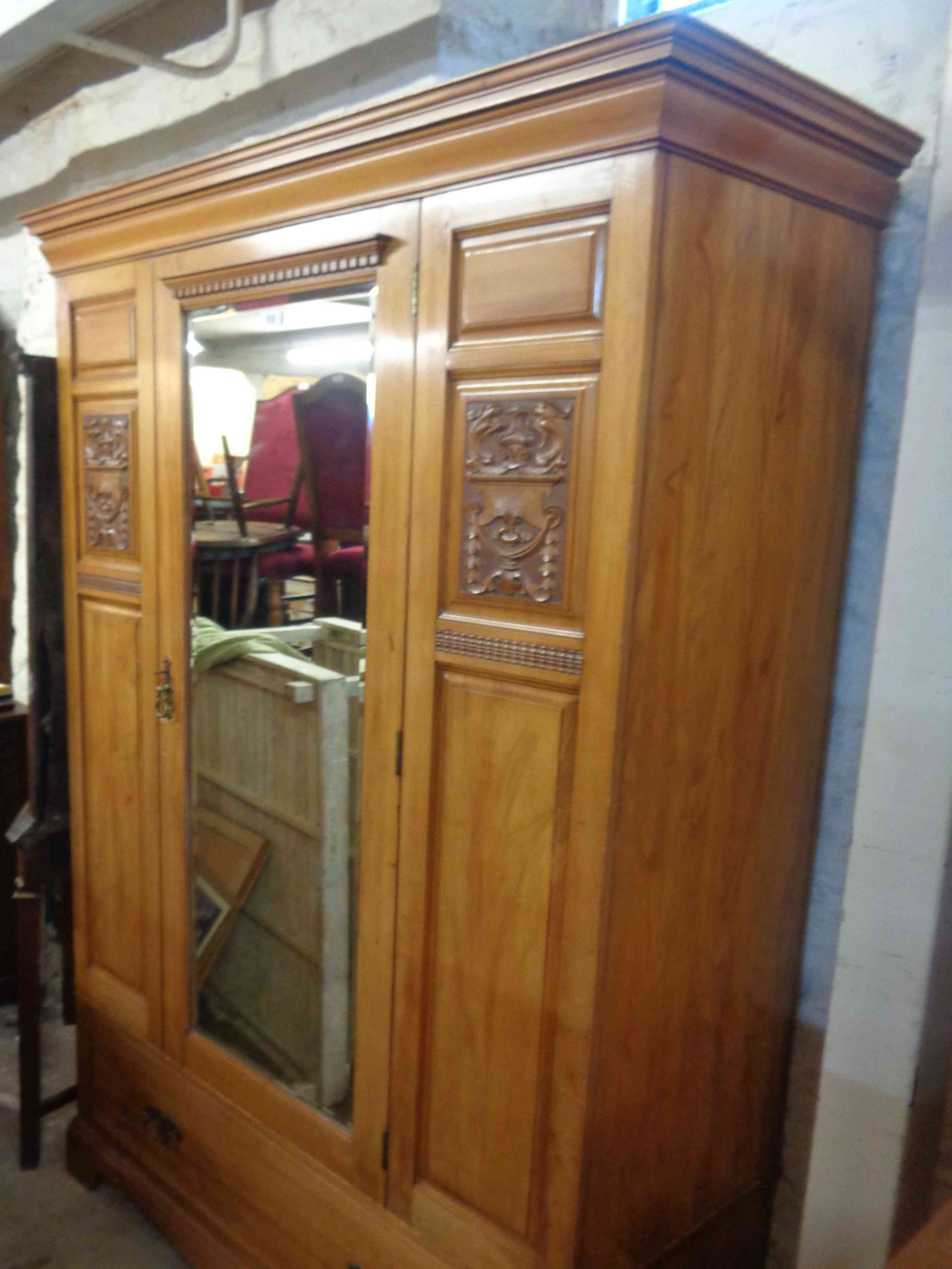 A 1.12m Edwardian satin walnut single wardrobe enclosed by a bevelled mirror panel door with deep