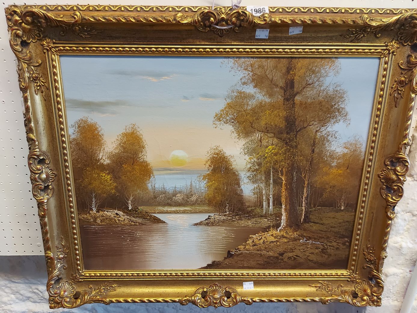 †Chapman: an ornate gilt framed oil on canvas, depicting a woodland river landscape at sunset -