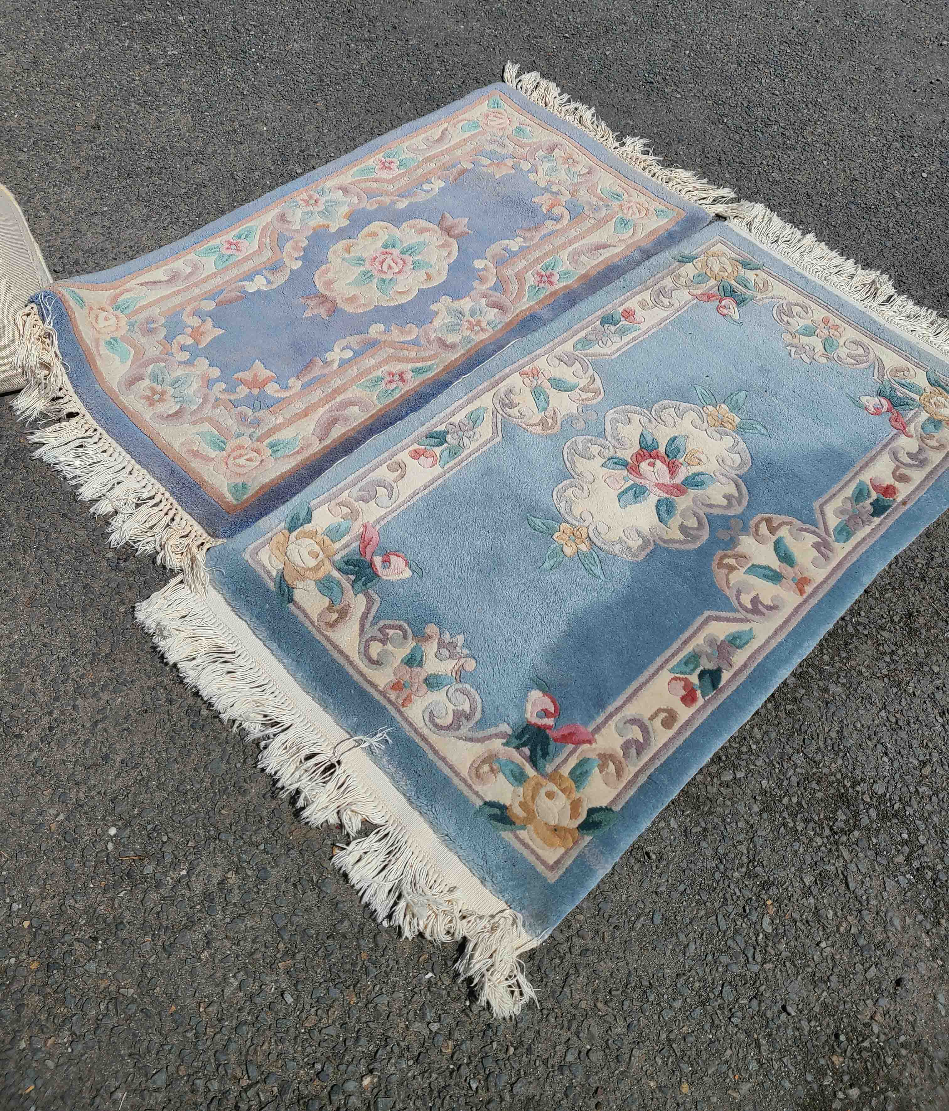 A pair of modern machine made Chinese washed wool rugs with floral decoration on blue ground