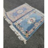 A pair of modern machine made Chinese washed wool rugs with floral decoration on blue ground