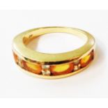 An Iliana marked 18k yellow metal ring, with four channel set orange topaz stones interspersed