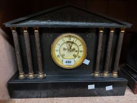 A large late Victorian black slate cased mantel clock of architectural design with six flanking
