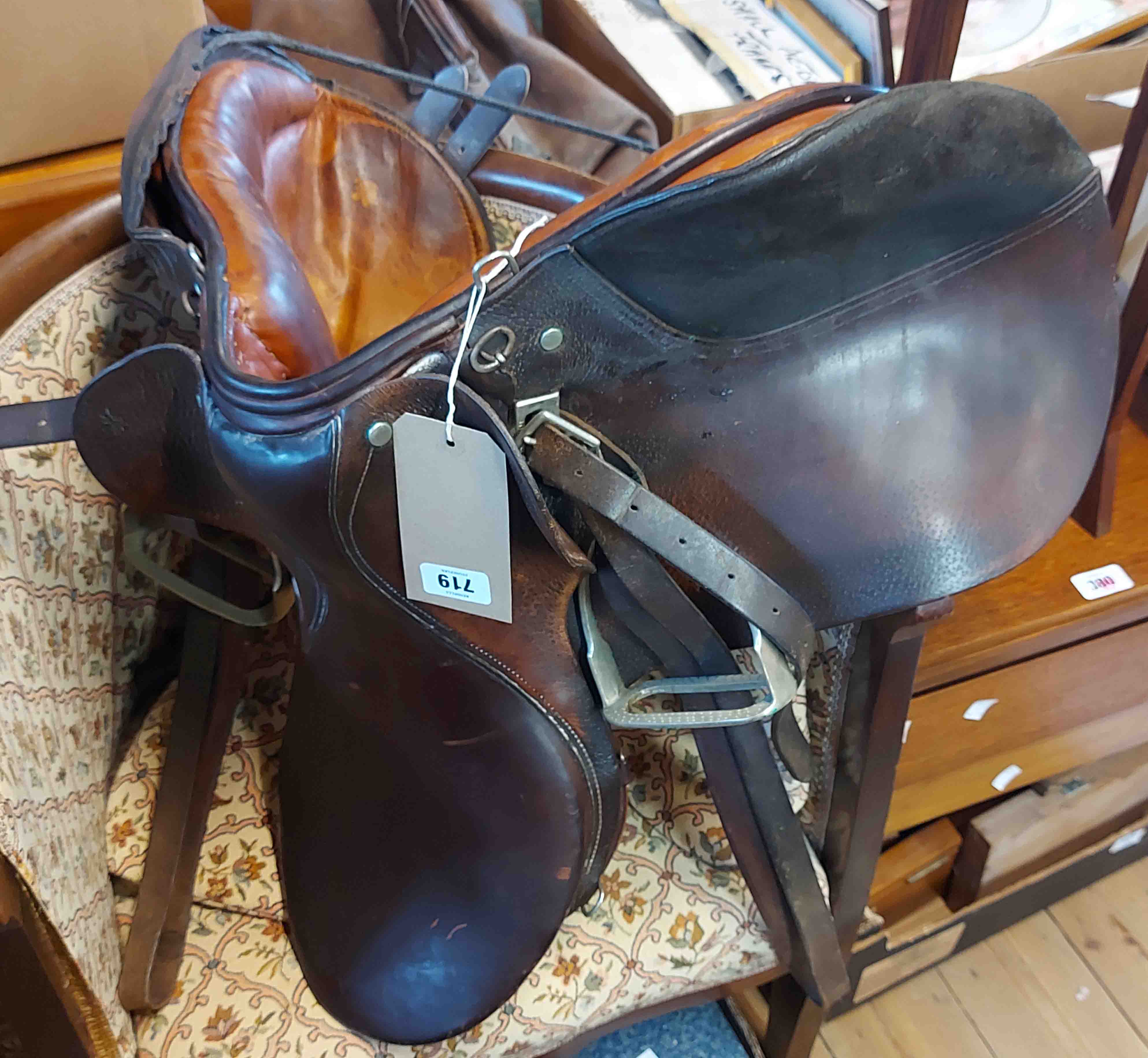 A Triumph Princess junior leather saddle - sold with two whips