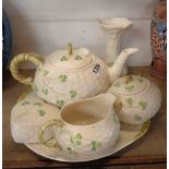 A quantity of Belleek porcelain comprising teapot, milk jug, sucrier, bread and butter plate,