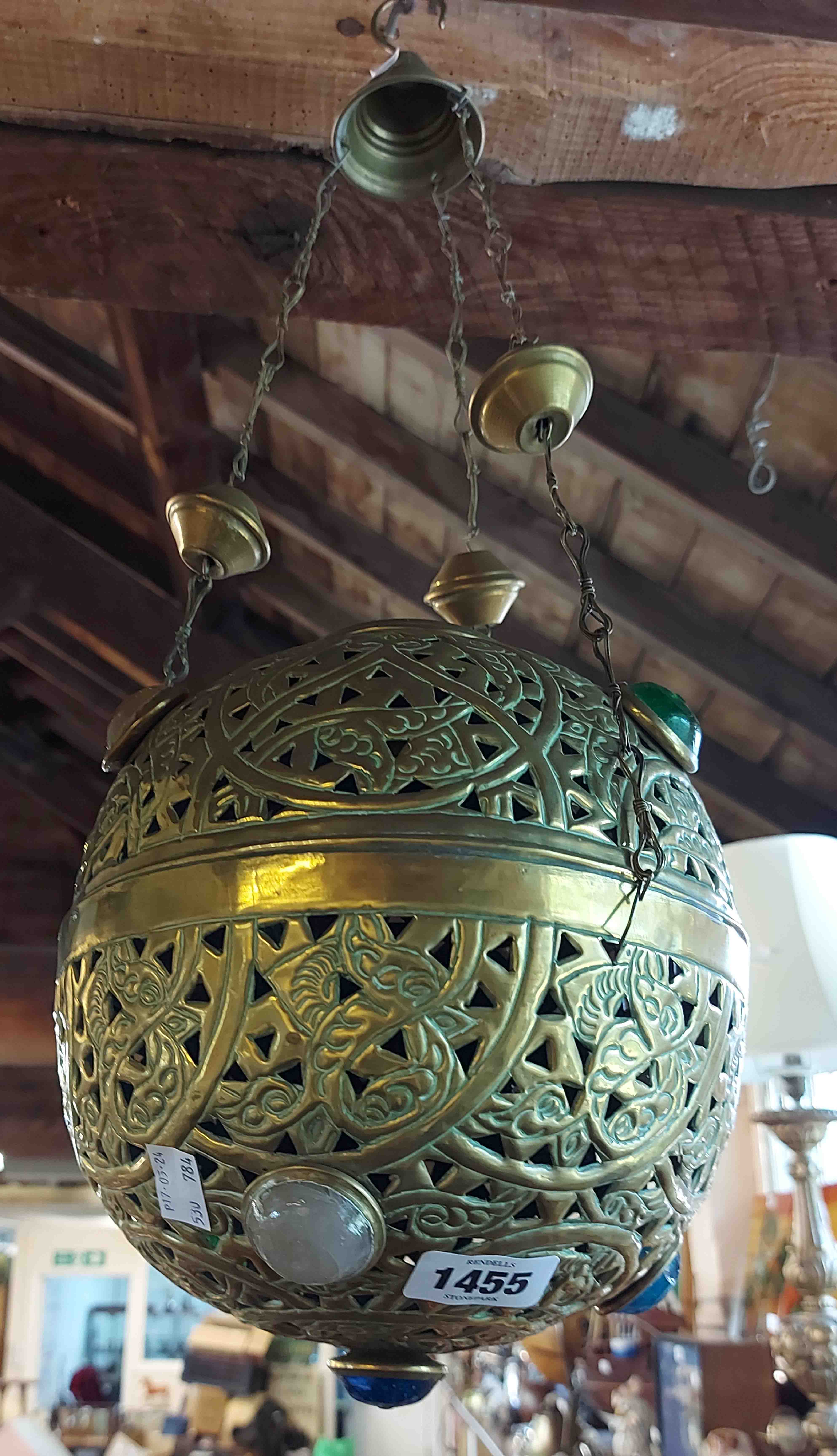 A decorative eastern pierced brass hanging lampshade with coloured cabochon decoration