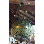 A decorative eastern pierced brass hanging lampshade with coloured cabochon decoration