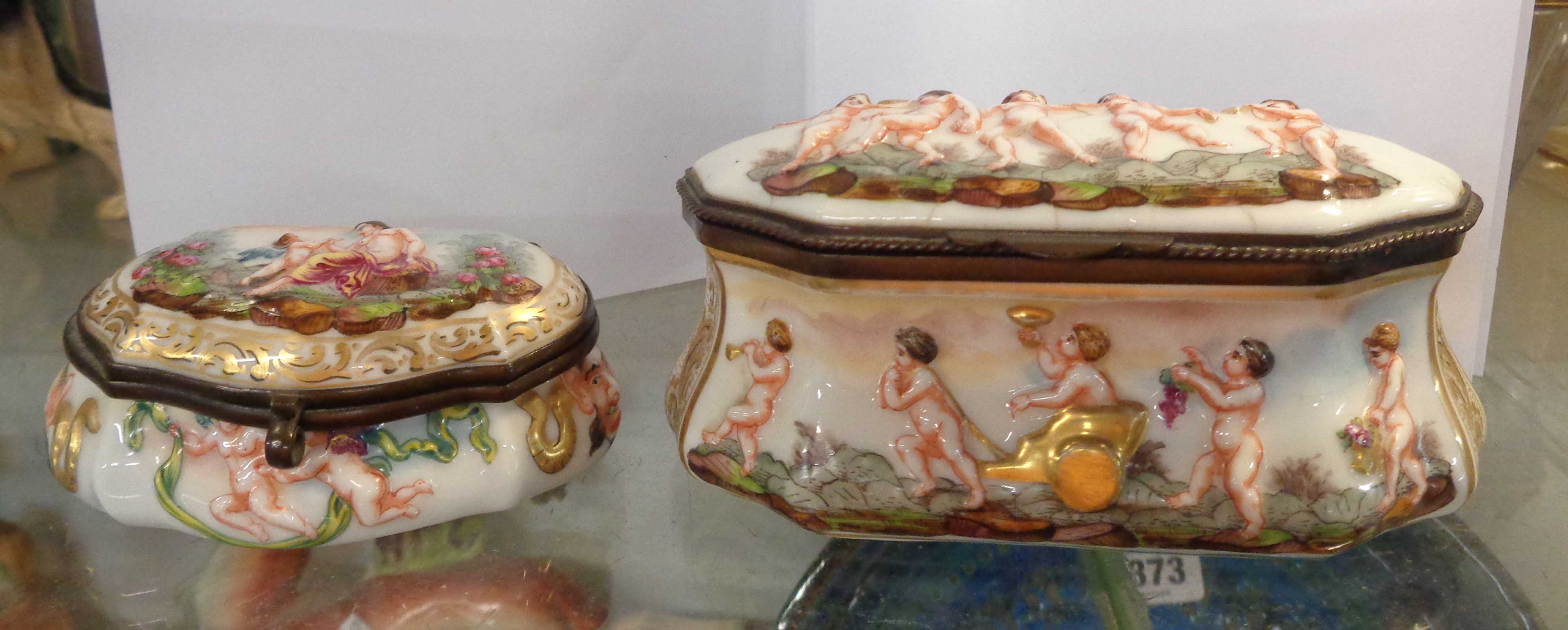 An antique Naples porcelain box with lift-top and gilt metal fittings, with typical moulded