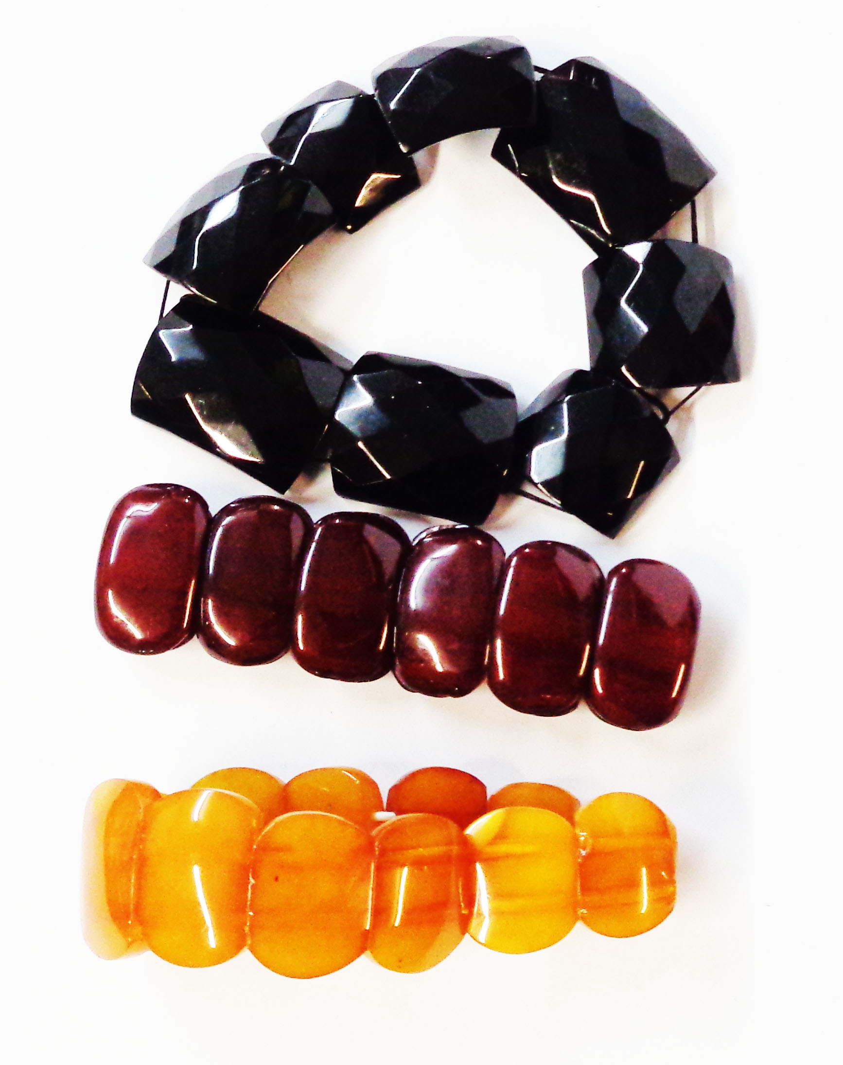 Two modern amber panel-link bracelets and another, all with elasticated strings