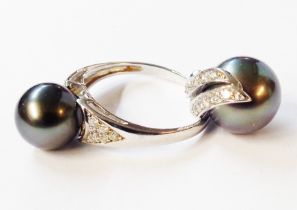 A 375 (9ct.) white gold black pearl solitaire ring - sold with matching pendant with two rows of