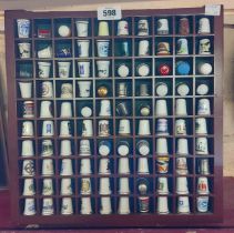 A wooden display case containing one hundred collectable thimbles