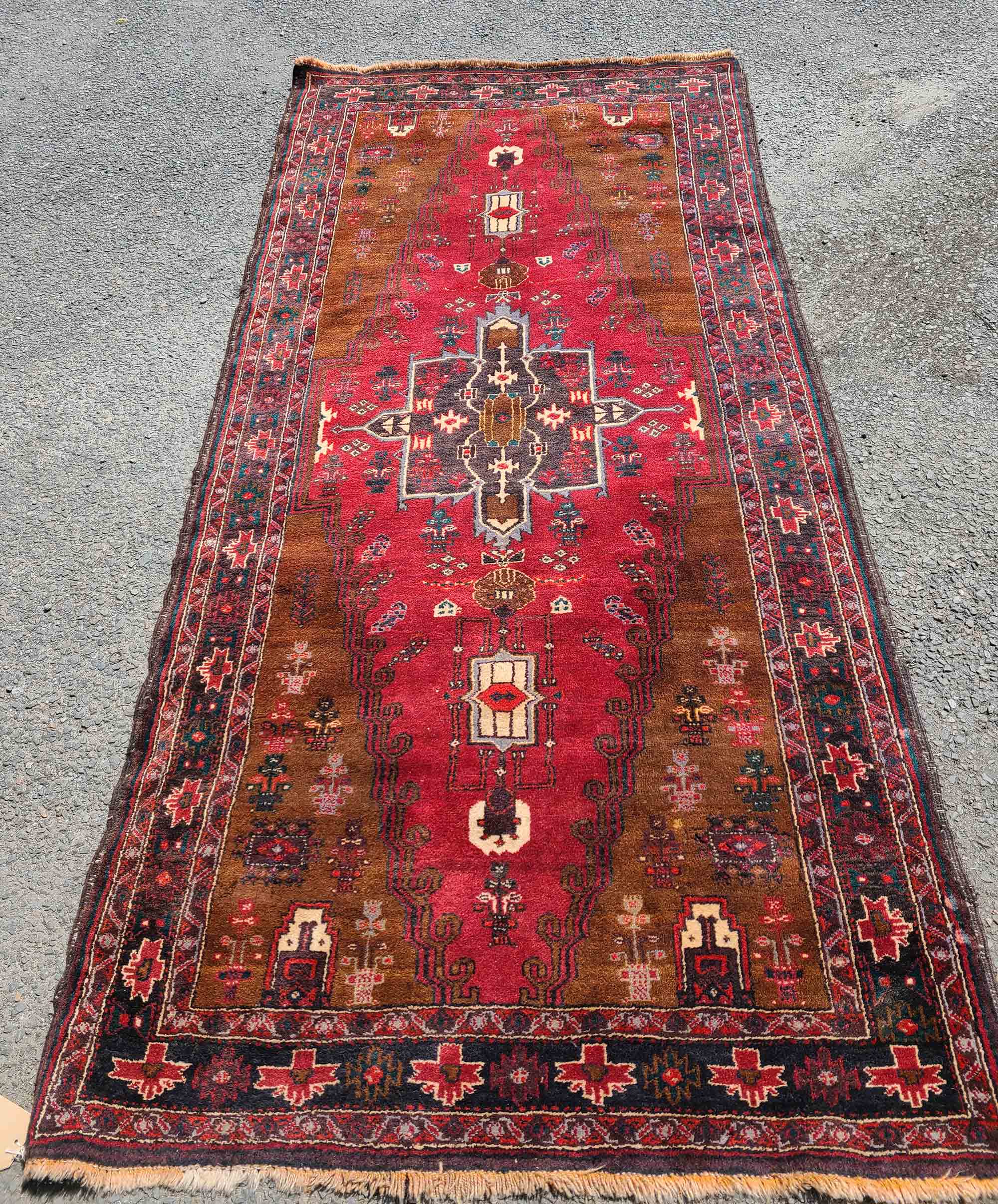 A vintage Persian handmade wool runner with decorative border on red ground - 2.5m X 1.15m